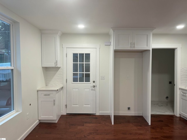 interior space featuring tasteful backsplash, white cabinets, and dark wood-type flooring