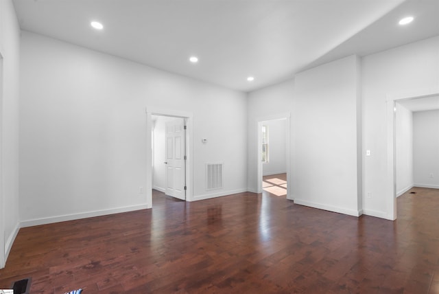 unfurnished room featuring wood-type flooring, visible vents, baseboards, and recessed lighting