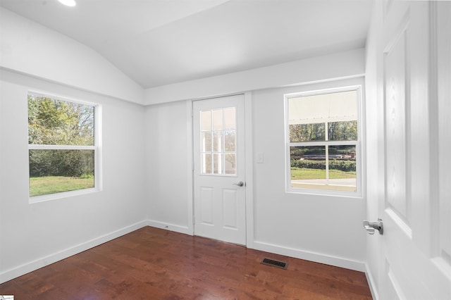 interior space with dark wood finished floors, visible vents, vaulted ceiling, and baseboards