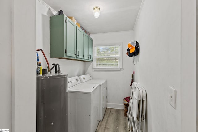 washroom with washing machine and dryer, light hardwood / wood-style flooring, ornamental molding, cabinets, and water heater