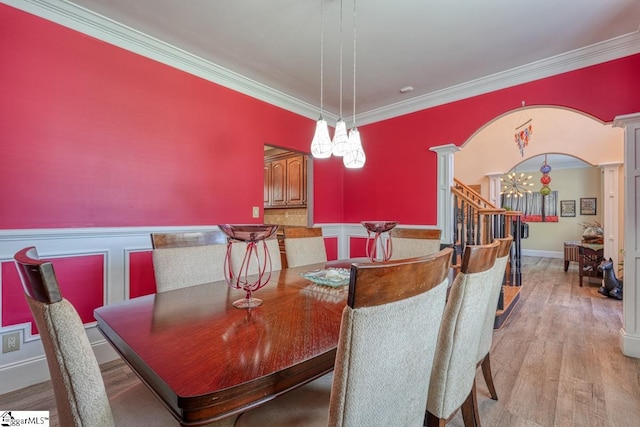 dining area with crown molding, a notable chandelier, and light hardwood / wood-style floors