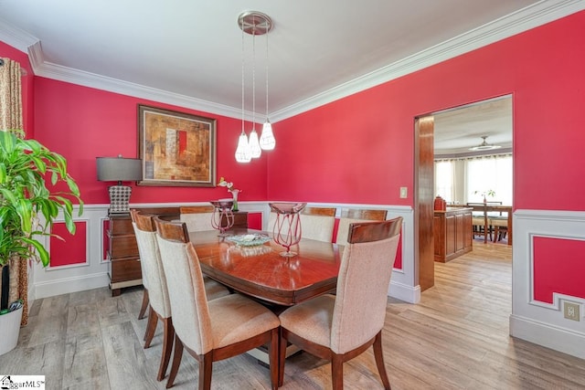 dining space with crown molding and light hardwood / wood-style floors