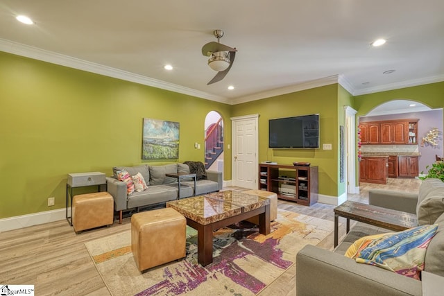 living room with ceiling fan, ornamental molding, and light hardwood / wood-style floors