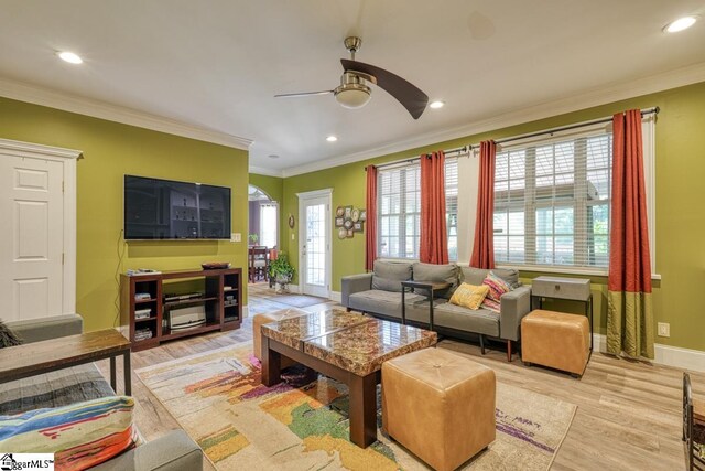 living room featuring crown molding, light hardwood / wood-style flooring, and ceiling fan