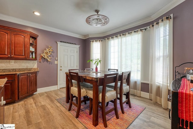 dining area featuring crown molding and light hardwood / wood-style floors