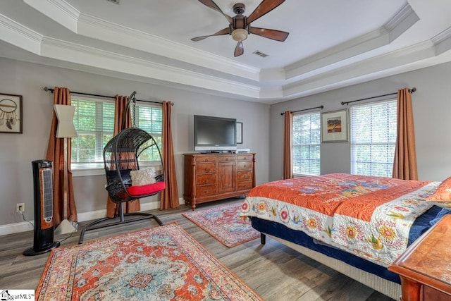 bedroom featuring ornamental molding, a raised ceiling, ceiling fan, and light hardwood / wood-style floors