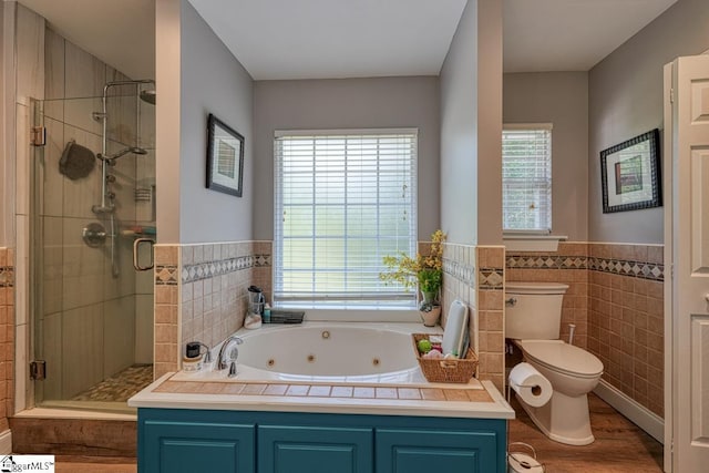 bathroom with tile walls, toilet, hardwood / wood-style flooring, and independent shower and bath