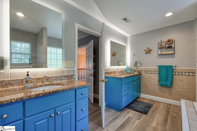 bathroom featuring vanity, tile walls, and wood-type flooring