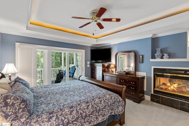 carpeted bedroom featuring ceiling fan, ornamental molding, a raised ceiling, and access to outside