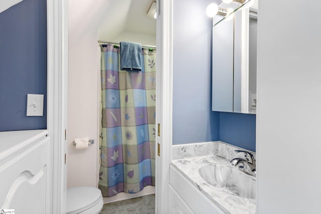 bathroom featuring vanity, toilet, vaulted ceiling, and a shower with shower curtain