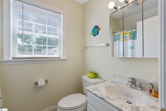 bathroom featuring a wealth of natural light, vanity, and toilet