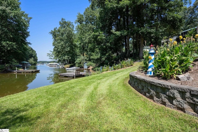 view of yard featuring a dock and a water view