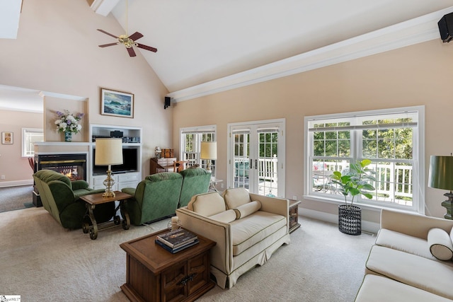 living room featuring ceiling fan, ornamental molding, high vaulted ceiling, and carpet