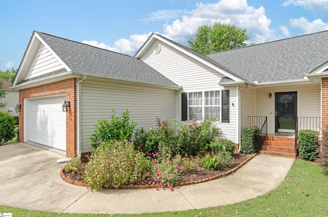 single story home featuring a garage, a shingled roof, concrete driveway, and brick siding