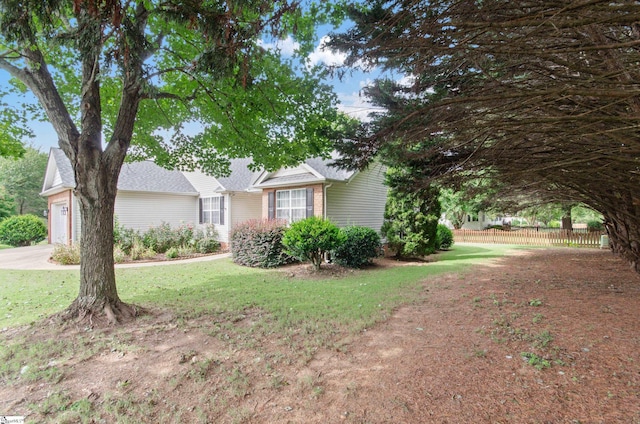 view of front of home featuring an attached garage, fence, and a front yard