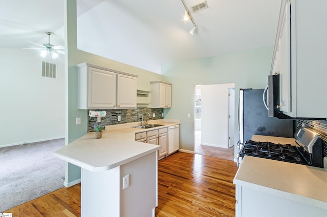 kitchen featuring a peninsula, visible vents, appliances with stainless steel finishes, and a sink