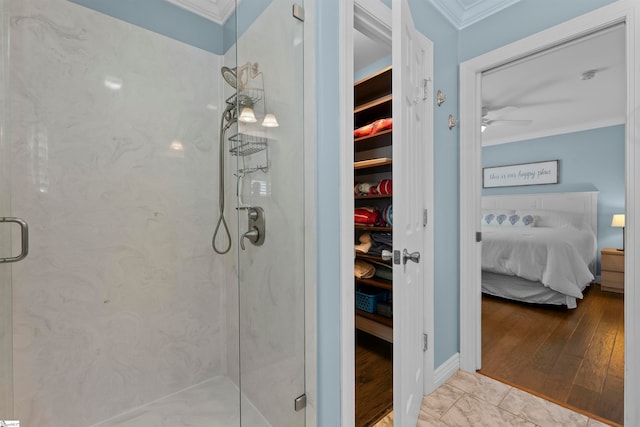 bathroom featuring crown molding, a shower with shower door, ceiling fan, and hardwood / wood-style floors