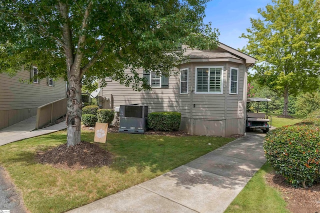 view of front of property with cooling unit and a front lawn