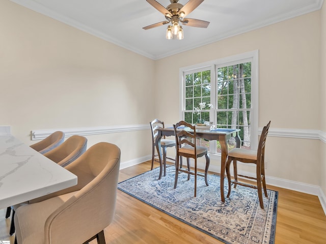 dining space with ceiling fan, light hardwood / wood-style floors, and ornamental molding