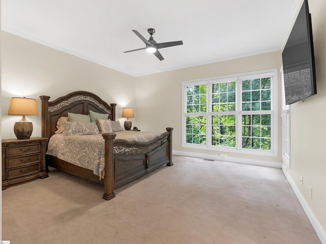 carpeted bedroom featuring ceiling fan and ornamental molding