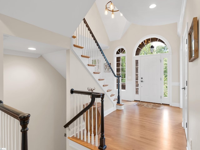 foyer with lofted ceiling, an inviting chandelier, and light hardwood / wood-style floors