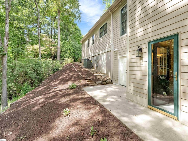 view of property exterior with central AC unit and a patio