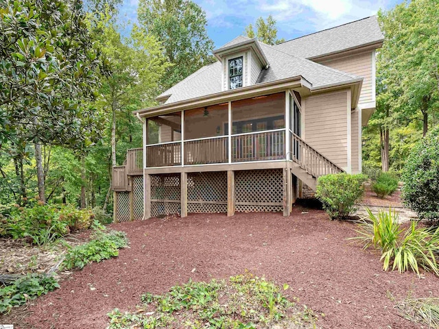 back of property with a sunroom, ceiling fan, and a wooden deck