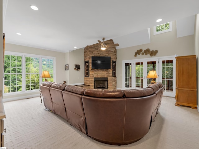 carpeted living room featuring a fireplace, french doors, and ceiling fan