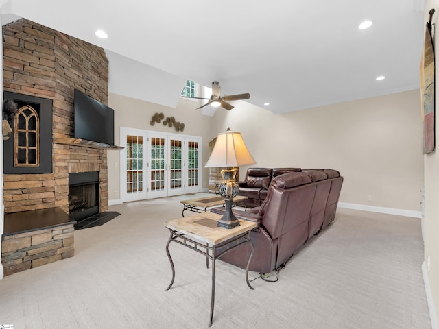 living room featuring light colored carpet, ceiling fan, and a stone fireplace