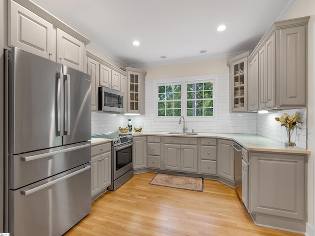 kitchen with stainless steel appliances, light wood-type flooring, and decorative backsplash