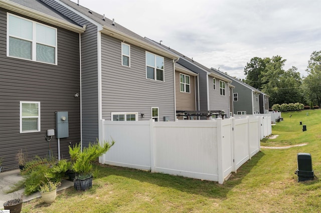 back of property with a yard and fence