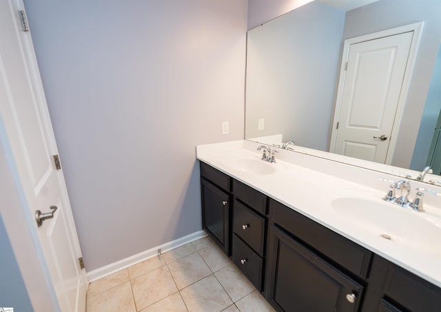 full bathroom with a sink, baseboards, double vanity, and tile patterned floors