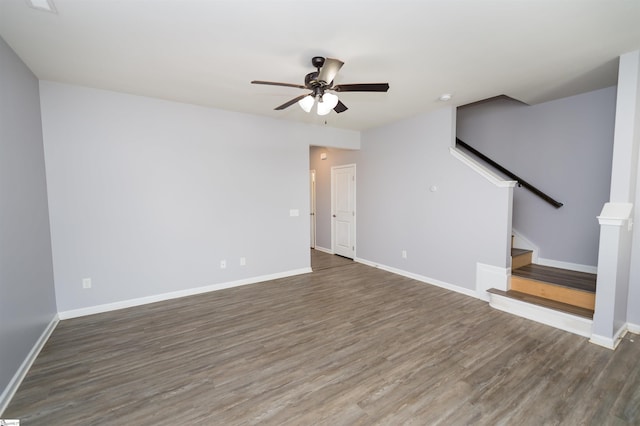 unfurnished living room with ceiling fan, baseboards, wood finished floors, and stairs