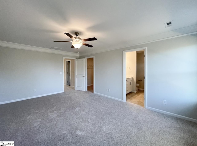 unfurnished bedroom featuring ceiling fan, crown molding, connected bathroom, and light carpet