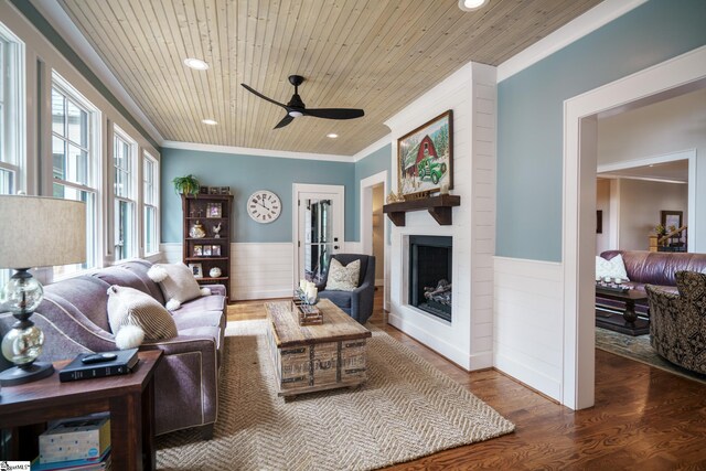 living room featuring a fireplace, ornamental molding, ceiling fan, wood ceiling, and hardwood / wood-style flooring