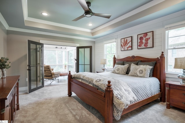 carpeted bedroom with french doors, ceiling fan, and a tray ceiling