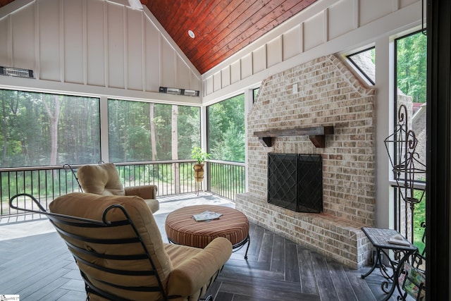 sunroom featuring vaulted ceiling, a brick fireplace, and wood ceiling