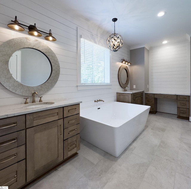 bathroom featuring crown molding, vanity, wooden walls, and a bathtub