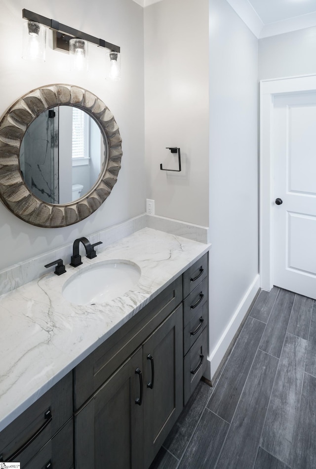 bathroom featuring crown molding, vanity, and hardwood / wood-style flooring