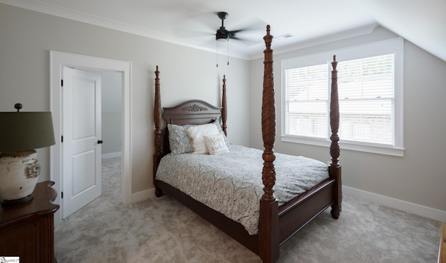 bedroom featuring light carpet, vaulted ceiling, crown molding, and ceiling fan