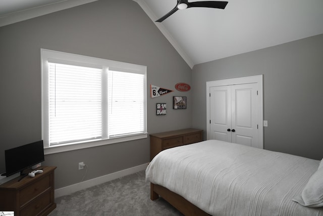 bedroom with a closet, ceiling fan, carpet, and vaulted ceiling