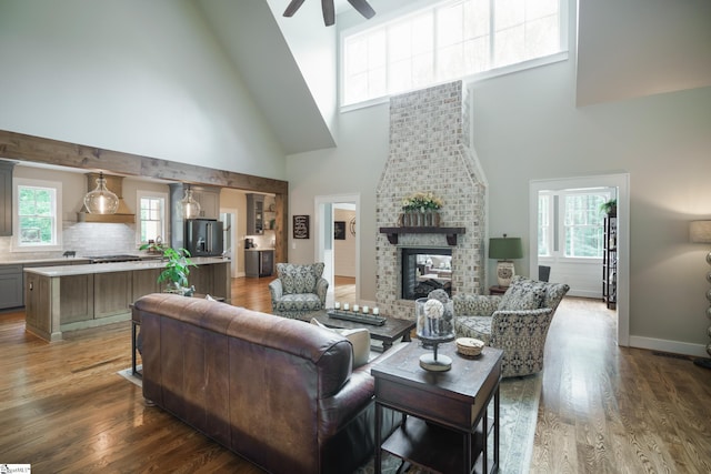 living room with a fireplace, plenty of natural light, a high ceiling, and ceiling fan