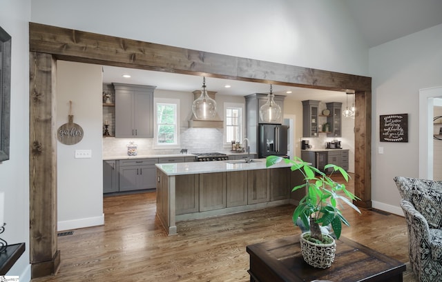 kitchen featuring appliances with stainless steel finishes, hardwood / wood-style floors, a kitchen island, and pendant lighting