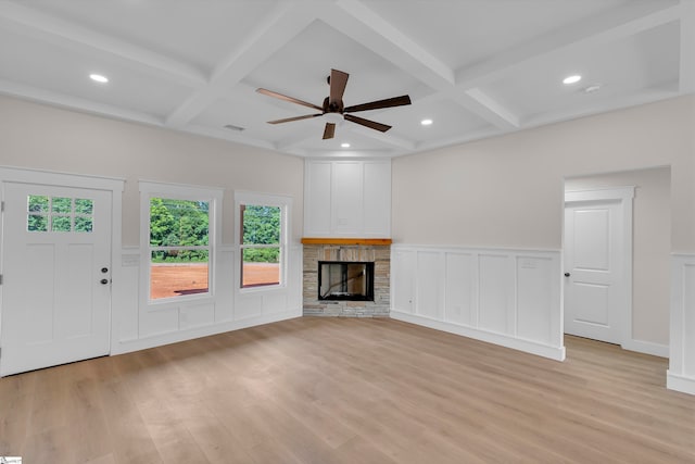 unfurnished living room with coffered ceiling, a fireplace, light hardwood / wood-style flooring, beam ceiling, and ceiling fan