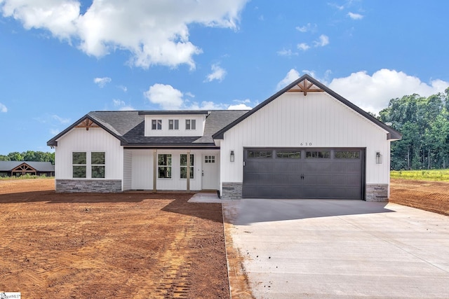 103 Leon Dr, Anderson, SC 29621 - modern farmhouse featuring stone siding, roof with shingles, and an attached garage