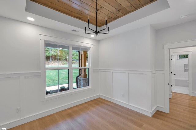 unfurnished room featuring wood ceiling, a chandelier, and light hardwood / wood-style floors