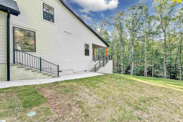 view of property exterior with a yard and a patio