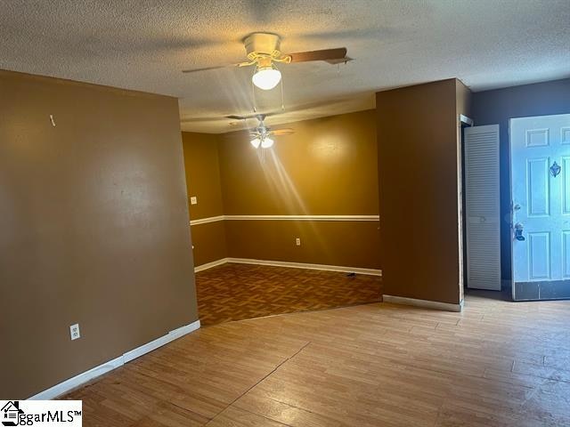 spare room featuring a textured ceiling, hardwood / wood-style floors, and ceiling fan