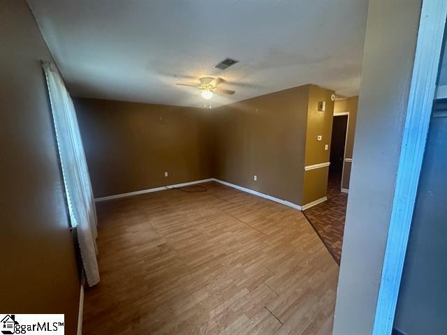 unfurnished room with ceiling fan and hardwood / wood-style flooring