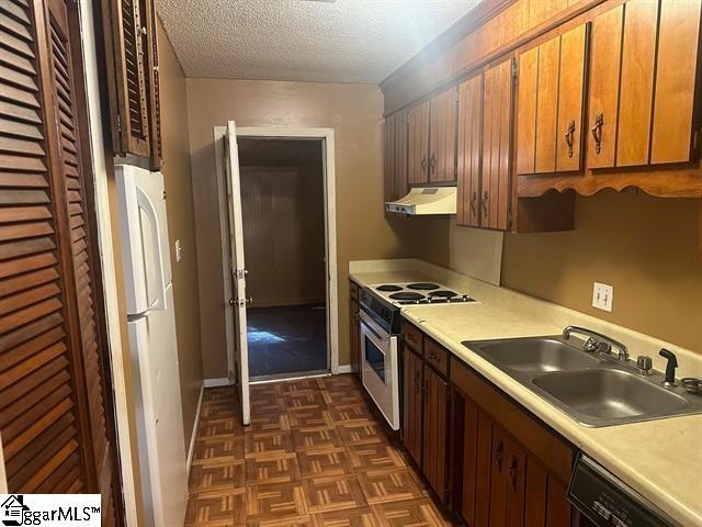 kitchen featuring a textured ceiling, black dishwasher, sink, stove, and white refrigerator